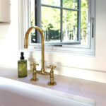 Unlacquered brass bridge kitchen faucet